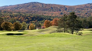 Un campo de golf con vistas despejadas a las colinas y árboles circundantes.