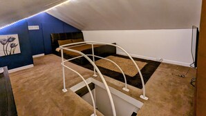 Un dormitorio con una cama litera, un cuadro e iluminación con tiras LED.