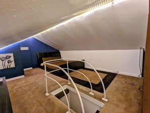 A room with a bunk bed, a blue accent wall, and a carpeted floor. - 3BR | Fully Fenced Front & Back Yards | Fast WiFi (Evansville)
