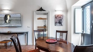 En spiseplads med et træbord, stole og kunst på væggene.