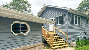 Une maison à deux étages avec un escalier en bois et des fondations en briques.