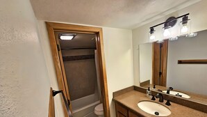 A bathroom with a shower, two sinks, a mirror, and a towel rack. - Village square 442, Center Village Copper Mountain,Pet Friendly includes parking (Copper Mountain)