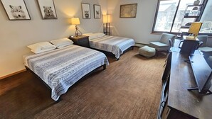 A hotel room with two beds, a desk, a chair, a lamp, and framed pictures on the wall. - Village square 442, Center Village Copper Mountain,Pet Friendly includes parking (Copper Mountain)