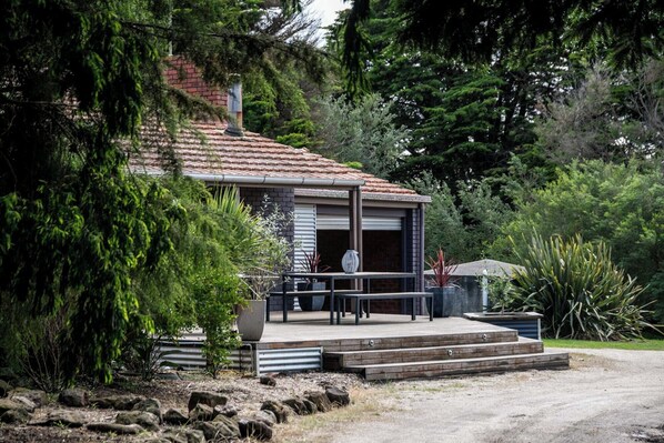 A house with a tiled roof, a front porch with steps, and a garage door. - Country Seaside Escape - Torquay (Surf Coast)