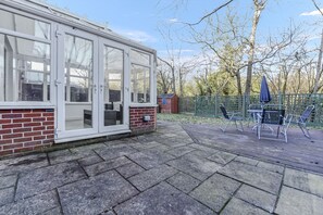 Enjoy indoor-outdoor living in this charming property with a conservatory and adjacent patio area.