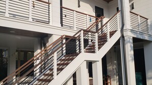 Un bâtiment à plusieurs niveaux, doté d’un escalier, d’un éclairage extérieur et d’une zone herbeuse.