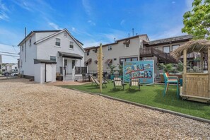 A residential area with houses, a grassy lawn, and outdoor seating. - Seaside Heights' Paradise House: 5BR (Seaside Heights)
