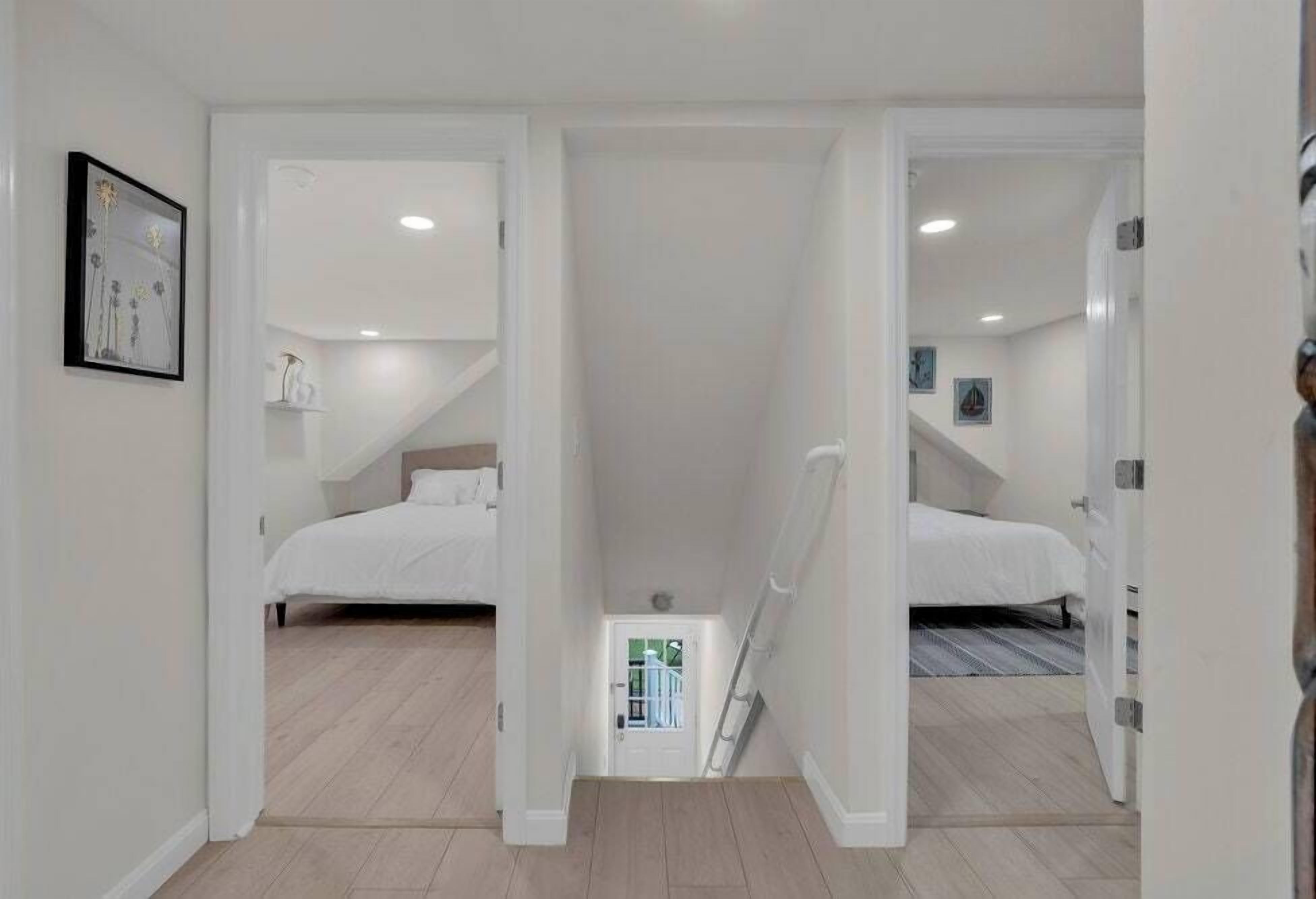 Une chambre avec deux lits, une petite salle de bain et un escalier menant à l’étage supérieur.