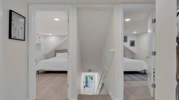 Une chambre avec deux lits, une petite salle de bain et un escalier menant à l’étage supérieur.