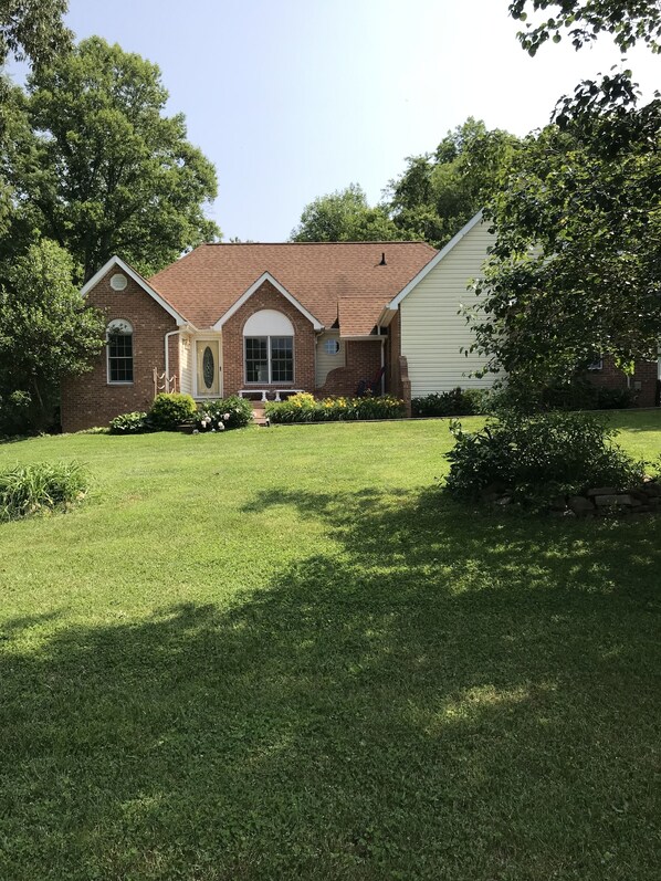 A two-story house with a brick facade, a gabled roof, and a front porch.