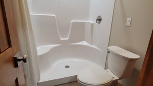 Een badkamer met een bad, toilet en douchegordijn.