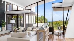 A modern interior with a sofa, a table, and a view of the outdoors.