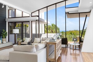 A modern interior with a sofa, a table, and a view of the outdoors.