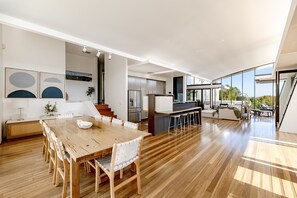 A spacious open-plan living area with a dining table, kitchen, and seating area.