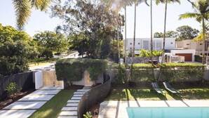 Ett bostadsområde med en swimmingpool, asfalterade gångvägar och ett varierat utbud av träd och buskar.