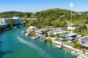 A coastal residential area with houses, a marina, and a hill in the background. - Luxurious Riverfront Retreat (Noosa Heads)