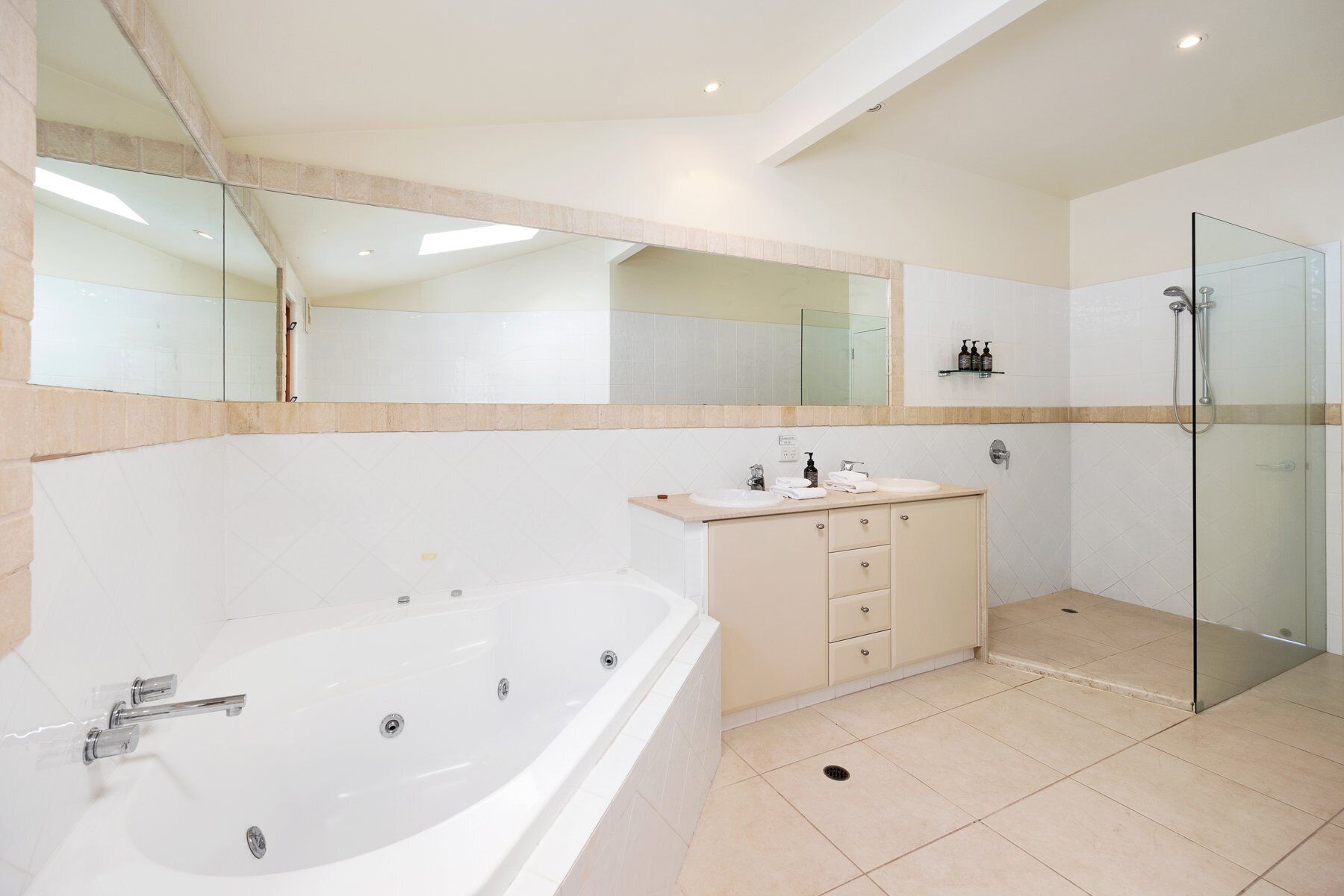 A modern bathroom with a freestanding bathtub, a glass shower enclosure, and a vanity with a mirror.