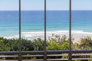 A view of the ocean through a window with a metal railing. - The Beach Shack - Getaway on Sunshine Beach (Sunshine Beach)