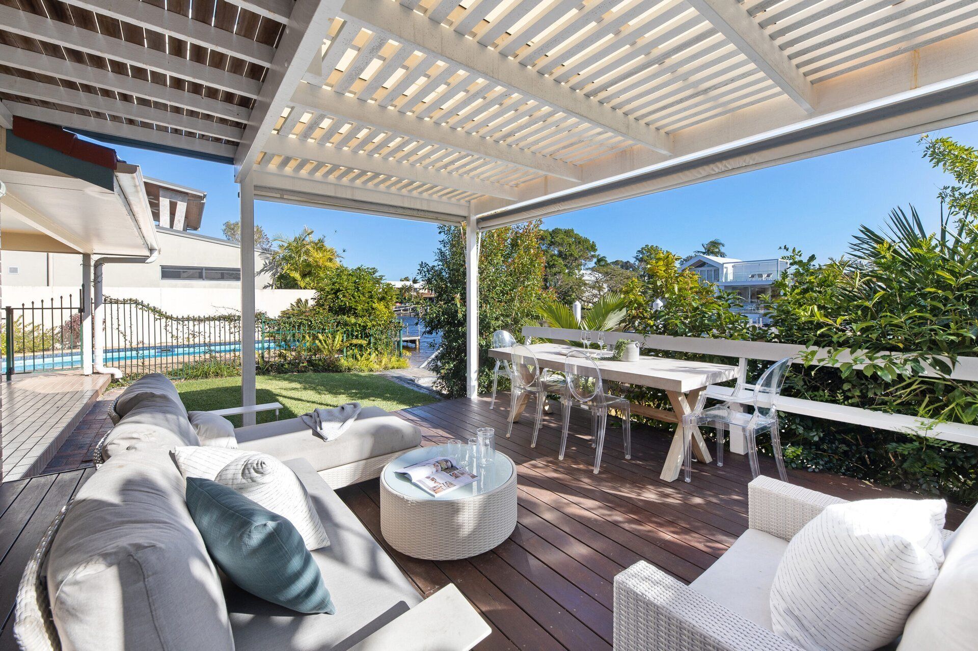 Une terrasse extérieure dotée d’un espace salon abrité, d’une piscine et offrant une vue sur le paysage environnant.