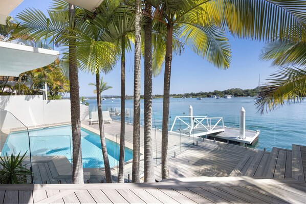 Relax by the pool surrounded by palm trees and enjoy the calm sea views.