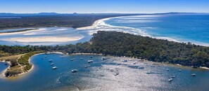Overlooking a serene bay with boats anchored, this property offers stunning views of the surrounding hills and beaches.