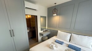 Ett hotellrum med en säng, ett sängbord, en spegel och en luftkonditioneringsanläggning.