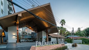 Palmyrah Suites har en modern exteriör med en tydlig entré och en skylt.