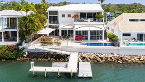 A modern two-story house with a pool, a dock, and a view of the water. - Luxury Riverfront: Private Pool, Water Views (Noosa Heads)