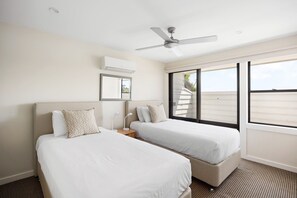 A hotel room with two beds, a ceiling fan, a large window, and a view of the outside. - The River Rest - Noosa Jetty Stay (Noosa Heads)