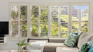 Una sala de estar con un sofá, una mesa de centro con una planta y un televisor.