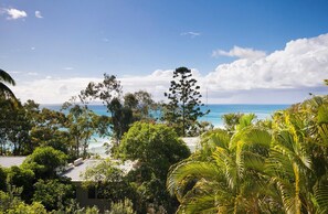 A coastal property with a view of the ocean, surrounded by lush greenery and trees. - Little Cove Apt - Spectacular View, Pool (Little Cove)