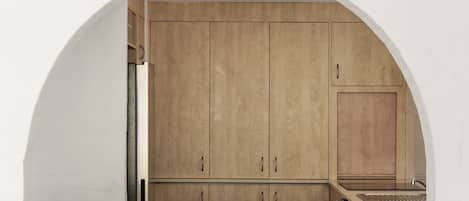 Una cocina con armarios de madera, una encimera y un lavamanos.