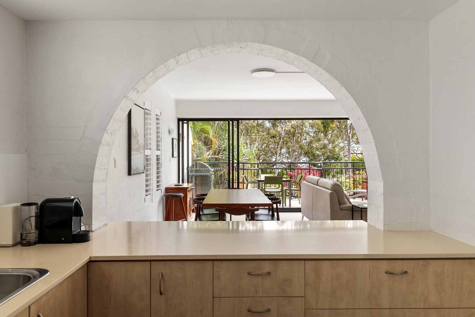A kitchen with a view of an outdoor dining area.