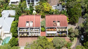 A residential building with multiple balconies, a swimming pool, and surrounding greenery. - Bayona 2 - Family Beach Charm (Little Cove)