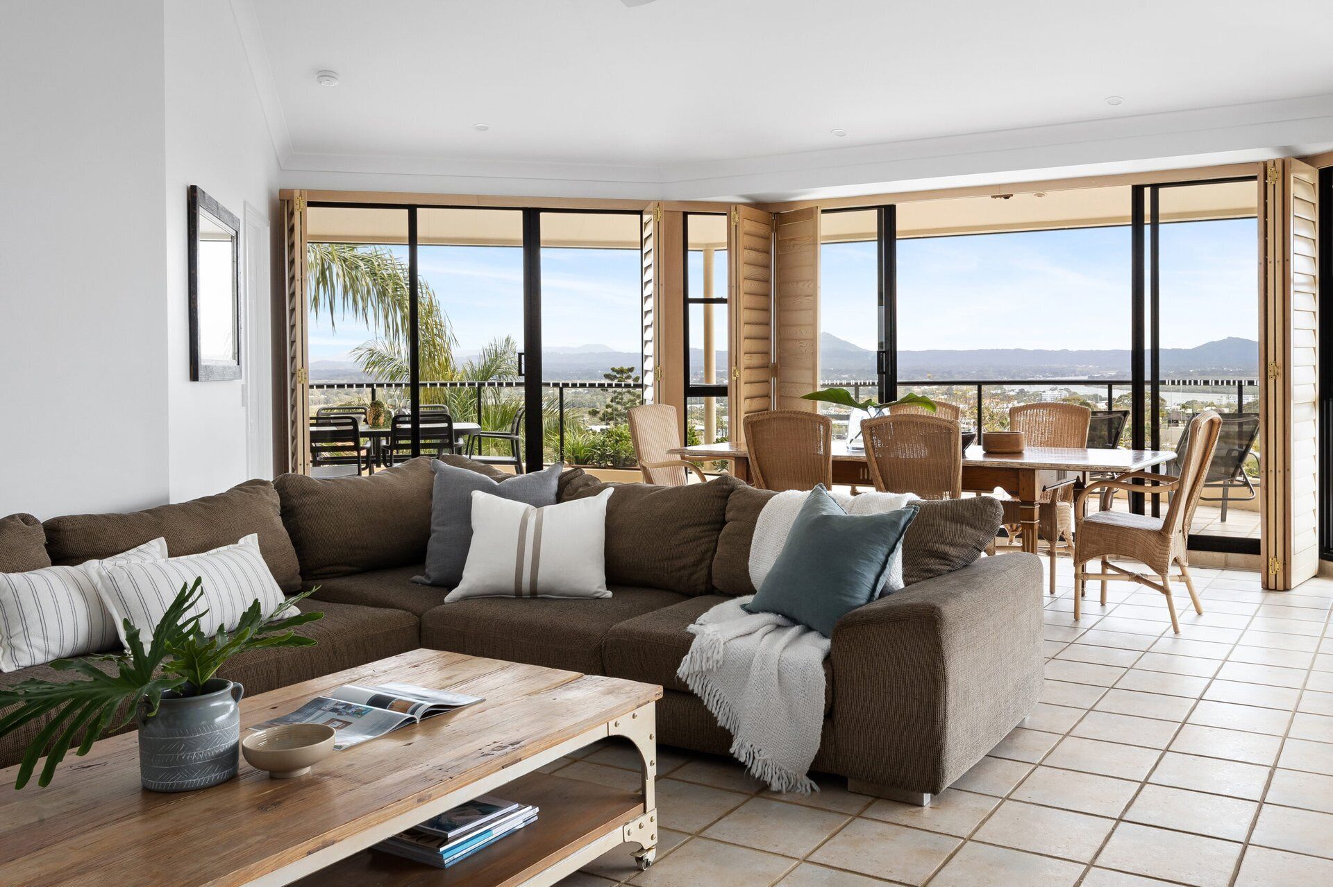 A living room with a sofa, coffee table, and a view of the outdoors.