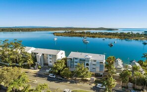 A coastal hotel with multiple buildings, a marina with boats, and a clear view of the sea.