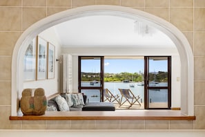 Enjoy a serene view of the marina from the large arched window in this cozy living space.