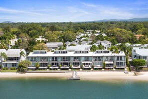 Un hotel sulla spiaggia con edifici a più piani, una spiaggia sabbiosa e una vista limpida sull'oceano.