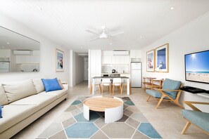 A modern living room with a sofa, coffee table, and seating area.