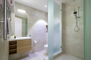 A modern bathroom with a glass shower enclosure, a wooden vanity, and a toilet. - Fairshore 15 - Noosa Main Beach Stay (Noosa Heads)