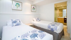 A hotel room with two beds, a ceiling fan, and a bathroom visible through an open door.