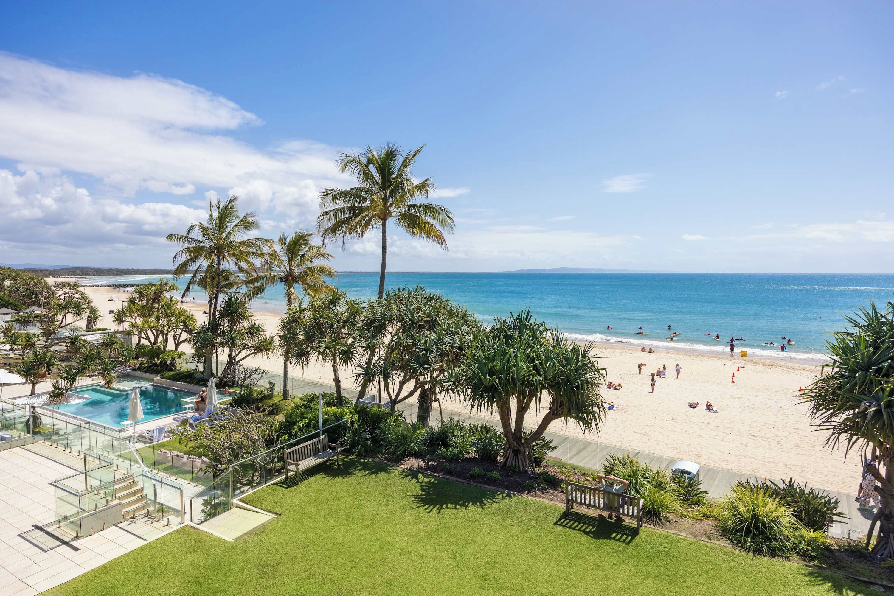 A resort with a pool, beach, and ocean view.
