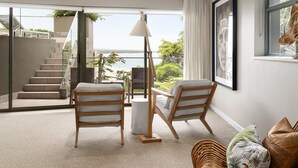 Un salon moderne avec vue sur la mer, un escalier et une grande fenêtre.