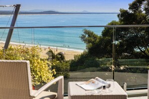 Uma varanda com vista para a praia e o oceano.