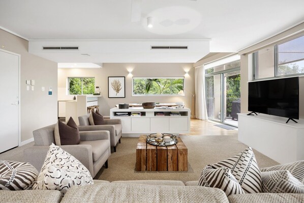 A modern living room with a sofa set, a coffee table, and a television.