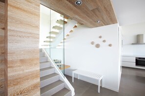 Ein modernes Interieur mit einer Treppe, einer Bank und einem Küchenbereich.