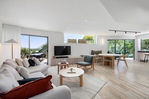 Una sala moderna con sofá, mesa de centro y televisor.