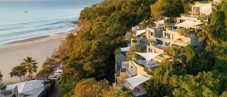 A coastal residential area with modern houses, a beach, and a clear view of the sea.