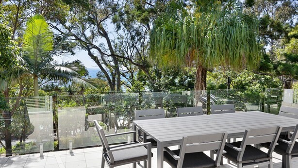 An outdoor patio with a glass railing, a table, and chairs. - Kareka - Little Cove Serenity with Pool (Little Cove)