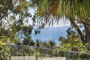 Overlooking a tranquil sea, this serene coastal landscape offers a secluded retreat with lush greenery and a clear view.